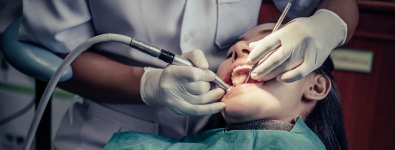 20'lik diş tedavisi yapılır dişçi koltuğuna oturmuş olan hastanın ağzında.