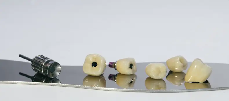 İmplant Çeşitleri Nelerdir? 9 İmplant Diş Çeşidi ve Özellikleri Nelerdir? 5 İmplant çeşitleri gösterilir mavi zeminin üzerinde ki dişlerin üzerinde.